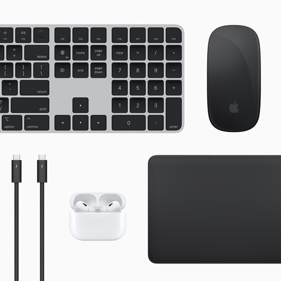 Mac-tilbehør vist ovenfra: Magic Keyboard, Magic Mouse, Magic Trackpad, AirPods og Thunderbolt-kabler
